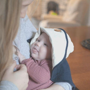 baby wearing the mobobaby nursing cover and hat in nautical navy